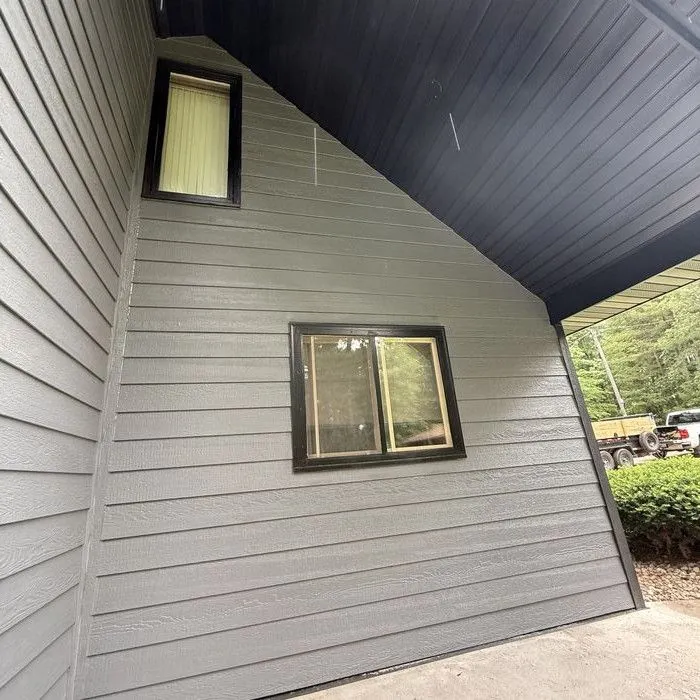 Gable corner in dark lap siding under a black soffit