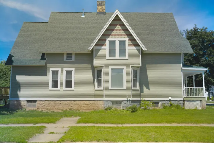 Side of the finished house in sage siding with a new wood deck